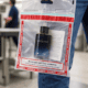 Traveler holding a sealed duty-free STEB bag with cologne inside at airport security checkpoint